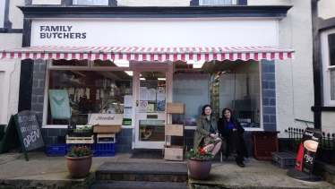 Janet in front of a butchers.